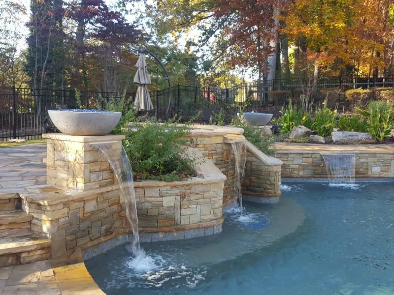 Pool with natural stone waterfall and hardscaping by 4 Seasons